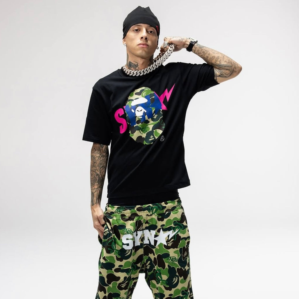 BAPE x Syna World graphic tee featuring a camouflage ape head logo